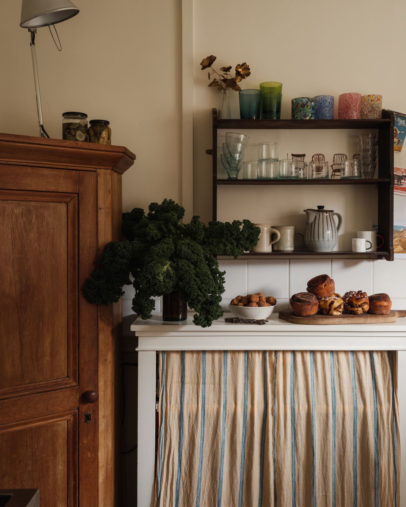 Image may contain Shelf Indoors Interior Design Lamp Plant Potted Plant Furniture Sideboard Cup and Chair